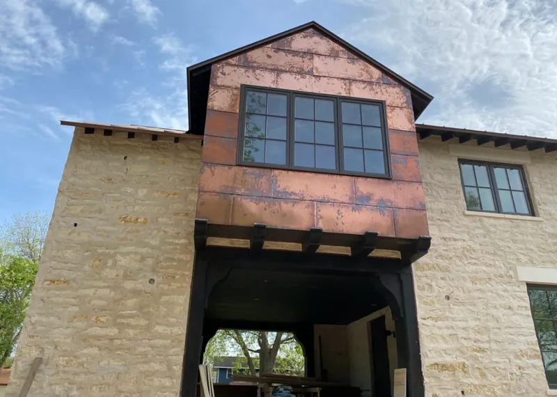 Copper metal panel facade on a stone building for Roof Repair in Comstock